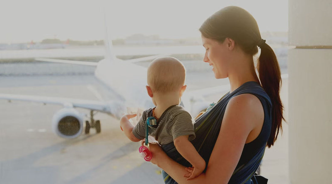 Parent holding smiling baby in airplane cabin with travel essentials from EasyBub